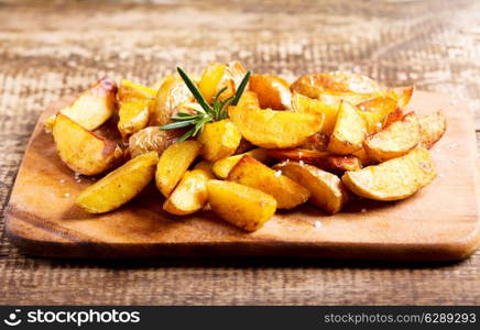 roasted potatoes with rosemary on wooden board