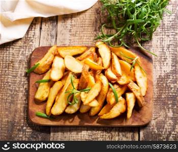 roasted potatoes with rosemary on wooden table
