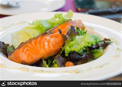 roasted salmon and fresh vegetable salad on white dish