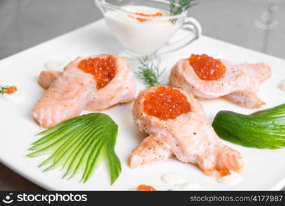 roasted salmon filet with red caviar, cucumbers and sauce