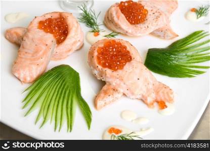 roasted salmon filet with red caviar, cucumbers and sauce