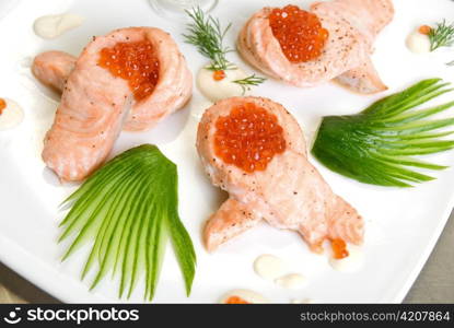 roasted salmon filet with red caviar, cucumbers and sauce