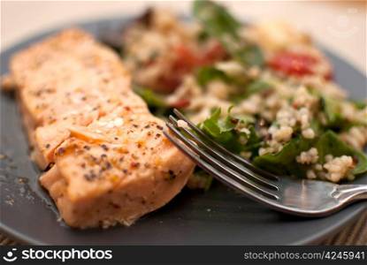 roasted salmon fillet with fresh green leaves salad and quinoa