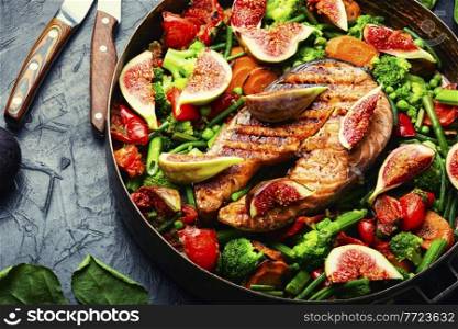 Roasted salmon steak with figs.Baked trout with garnish. Trout steak fried with vegetables.