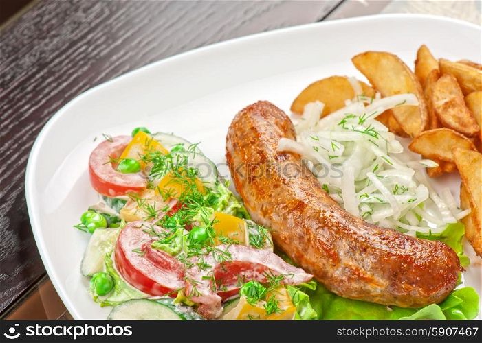 Roasted sausage. Roasted sausage with vegetables closeup