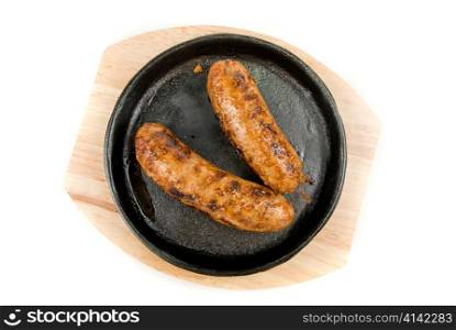 Roasted sausages at pan on a white background