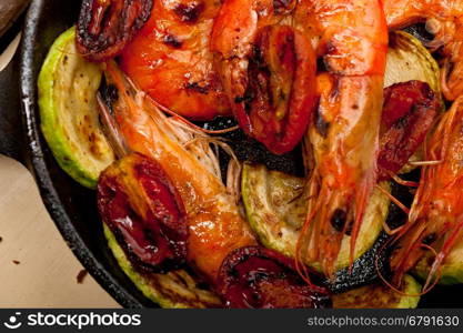 roasted shrimps on cast iron skillet with zucchini and tomatoes