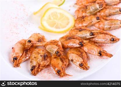 roasted shrimps with lemon closeup isolated on a white background