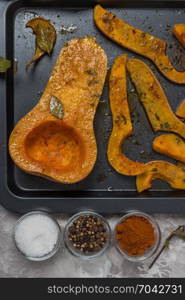 Roasted sliced butternut squash seasoned with salt, sweet pepper, pepper and thyme on baked dish