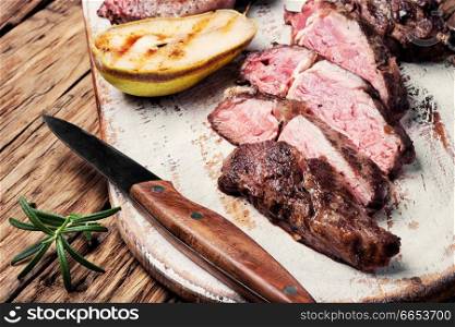Roasted sliced grill steak on wooden cutting board. Grilled beef steak
