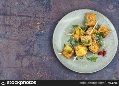 Roasted tofu cheese on sticks. Vegetarian food, space for text. Skewers with fried tofu cheese