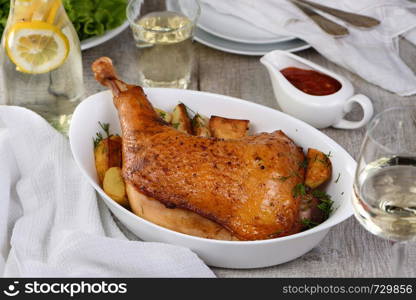 Roasted turkey leg with potatoes on the dinner table