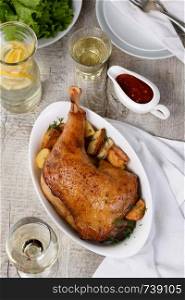 Roasted turkey leg with potatoes on the dinner table
