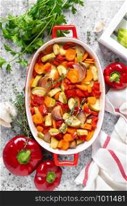 Roasted vegetables. Carrot, zucchini, onion and red pepper oven baked with herbs. Top view