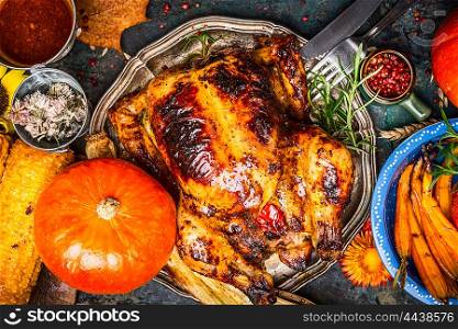 Roasted whole turkey or chicken served with pumpkin, grilled vegetables and corn, top view, close up