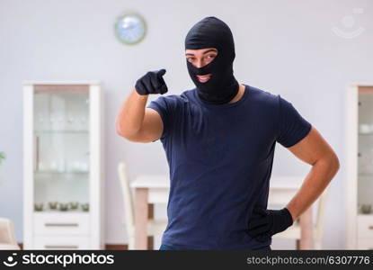 Robber wearing balaclava stealing valuable things