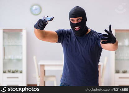 Robber wearing balaclava stealing valuable things