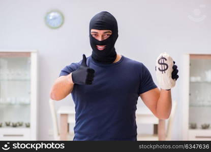 Robber wearing balaclava stealing valuable things