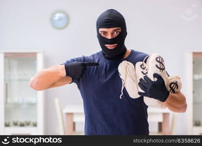 Robber wearing balaclava stealing valuable things