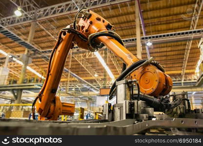 Robot arms handle tool keep automotive part to conveyor line.