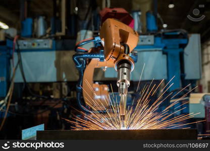 Robot is welding metal part in car factory