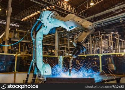 Robot is welding metal part in factory
