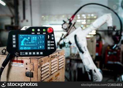 Robotic arm and its controller adept panel in a factory workshop . Industry robot programming software for automated manufacturing .. Robotic arm and its controller adept panel in a factory workshop