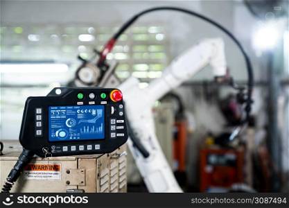 Robotic arm and its controller adept panel in a factory workshop . Industry robot programming software for automated manufacturing .. Robotic arm and its controller adept panel in a factory workshop