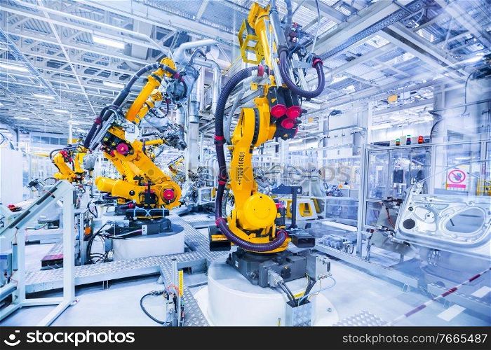 robotic arms in a car plant. robots in a car factory