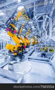 robotic arms in a car plant. robots in a car plant