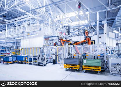 robotic arms in a car plant. robots in a car plant