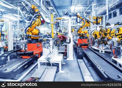 robots in a car factory. robotic arms in a car plant