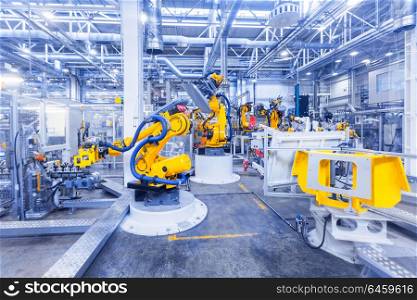 robots in a car plant. robotic arms in a car plant