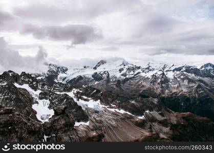 Rock cliff rise high behind cloud and deep snow mountain valley of Titlis in Engelberg, Switzerland