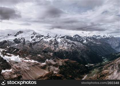 Rock cliff rise high behind cloud and deep snow mountain valley of Titlis in Engelberg, Switzerland