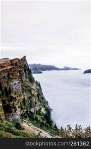 Rock cliff rise high over cloud and deep mountain valley of Titlis in Engelberg, Switzerland