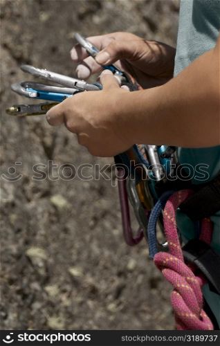 Rock climber sorting climbing equipment