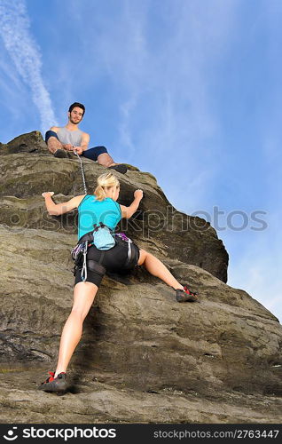 Rock climbing active young woman man holding rope on top