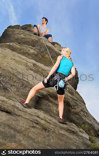 Rock climbing active young woman man holding rope on top