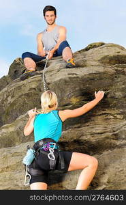 Rock climbing active young woman man holding rope on top