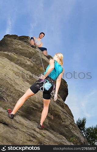 Rock climbing active young woman man holding rope on top