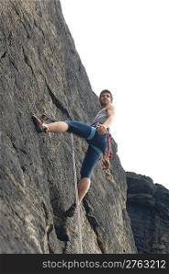 Rock climbing fit man on rope sunny day