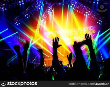 Rock concert, happy people silhouettes, raise up hands, disco party with large group of dancing man, bright colorful stage lights, active lifestyle, music entertainment, nightclub, new year eve