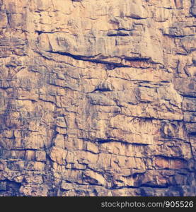 Rock face texture of large rocky cliffs with retro Instagram style filter effect