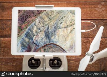 rock formation and creek - aerial view. Colorful rock formation and stream along Onion Creek in Moab area, Utah - reviewing an aerial image on a digital tablet mountaed on a drone radio controller