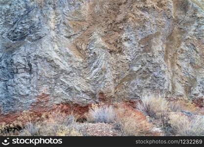 Rock formation and steep cliff with a desert vegetation along Onion Creek in Moab area, Utah