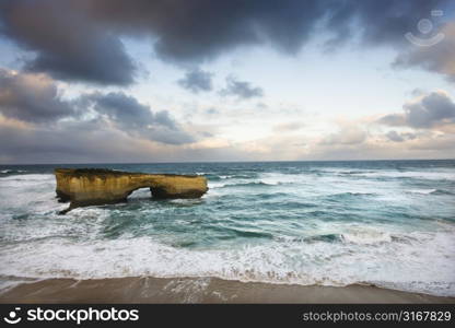 Rock formation forming arch on coastline of Great Ocean Road, Australia.