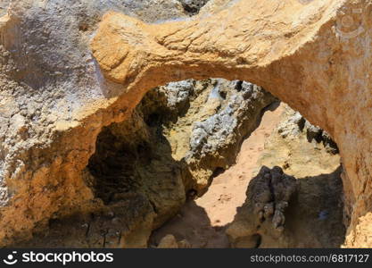 Rock formations (natural arch) on shore (Algarve, Portugal).