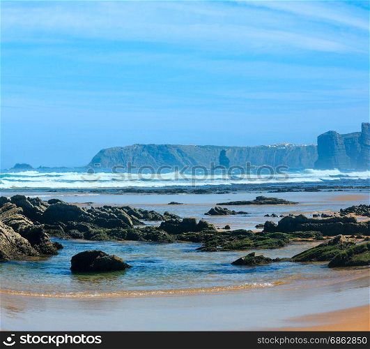 Rock formations on sandy beach (Algarve, Costa Vicentina, Portugal). Stormy weather. Two shots stitch image.