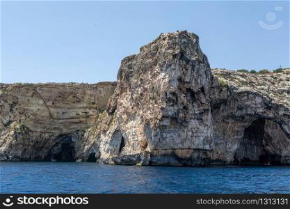 Rock in the sea near the coast of Crete island in Greece. rocks in the sea. Mountain slopes on the background of the sea shore. Seascape with mountain landscape. Photo of a sea landscape.